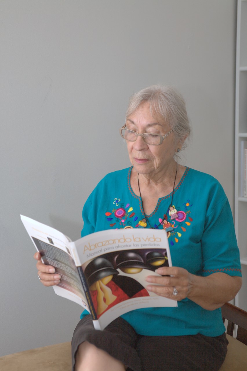 Una mujer sostiene y lee el libro Abrazando la Vida